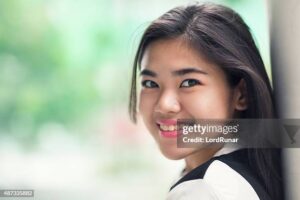 Portrait of young smiling woman outdoors with a defocused background.